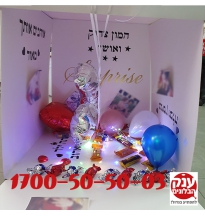 קופסא נפתחת עם בלונים ושוקולדים ותמונות